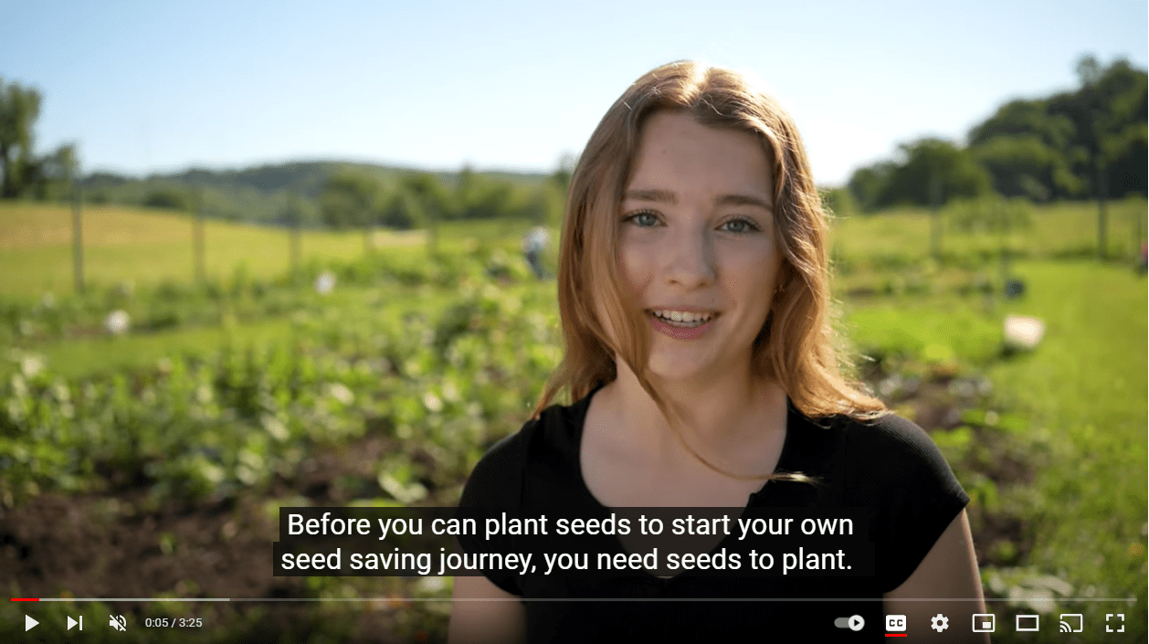 A woman stands in a garden and looks at the camera