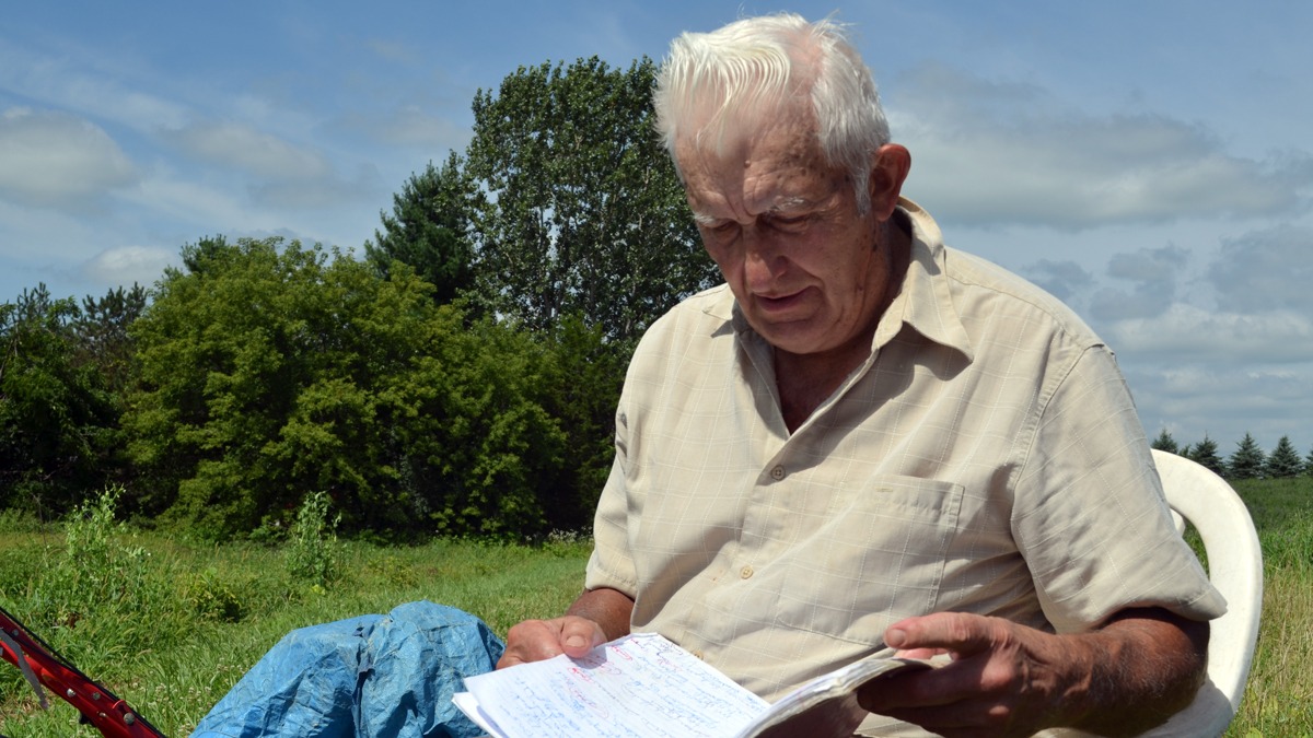 A man reads a notebook outside