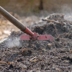 A garden tool raking through soil