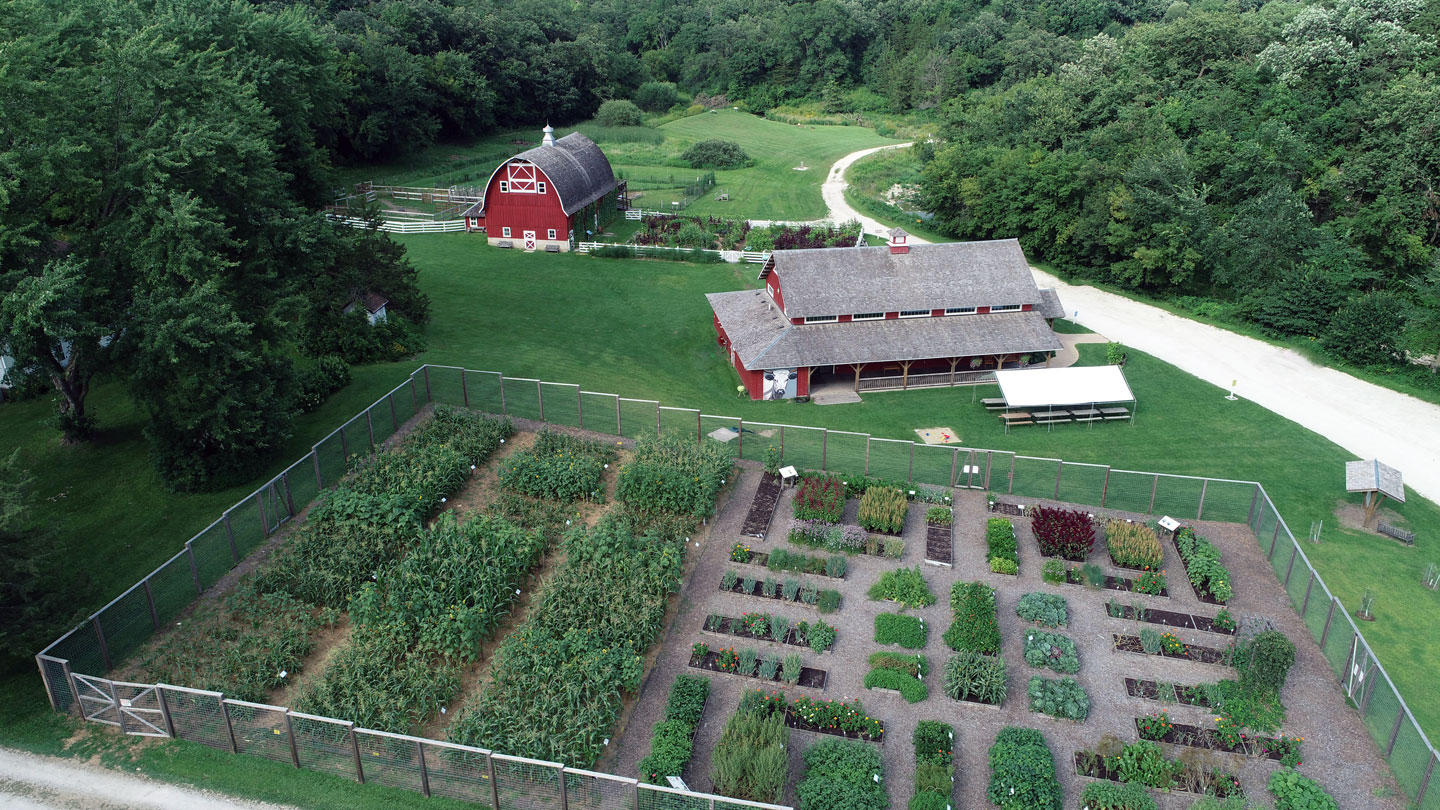 Arial photo of a large vegetable garden, a red building, and a barn.