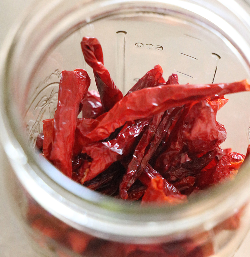 A glass jar of dried red chile peppers