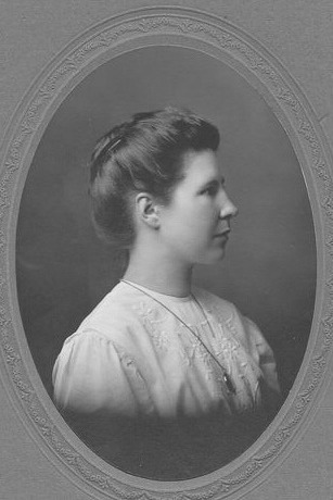 black and white portrait of a woman in a white blouse looking to her left, framed in an oval