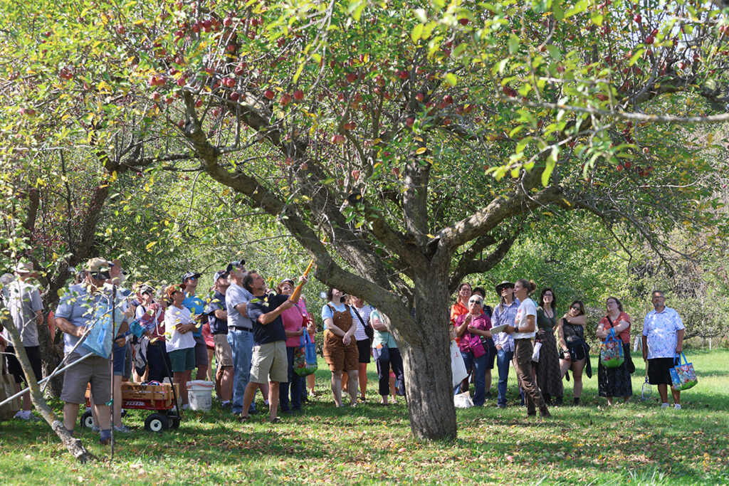 A tour group gather in the Seed Savers Exchange Historic Orchard at Heritage Farm.