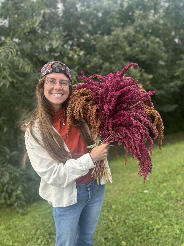 Sydney Weldon, ADAPT program manager, holds two varieties of amaranth grown at Heritage Farm.